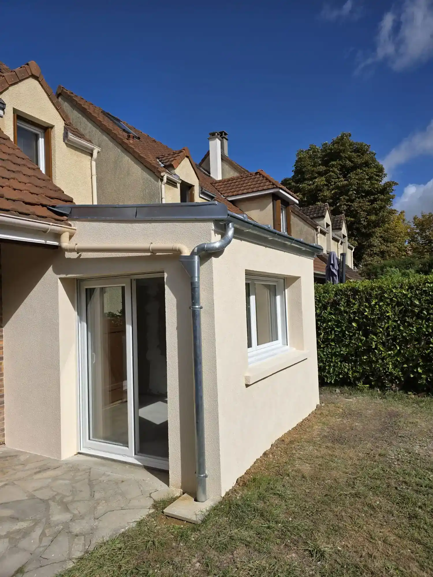 extension finalisée vue de côté avec portes , fenetres et volets roulants par ci rénovation